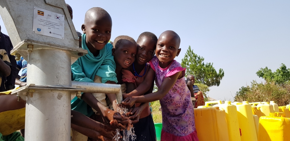 우간다 아루아지역 미테마을_수리한 식수펌프에 손을 씻으며 즐거워하는 아이들